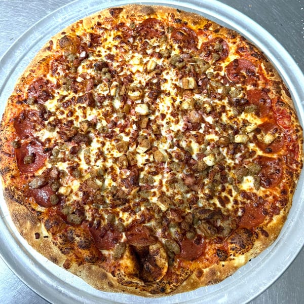 A whole AJ'S GRAB N GO pizza, loaded with pepperoni, sausage, bacon, and chicken.
